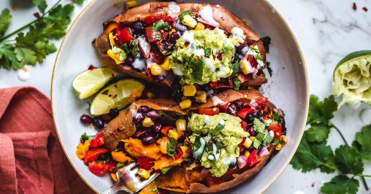 Black Bean-Stuffed Sweet Potatoes With Coconut Sour Cream and Guacamole | VegNews