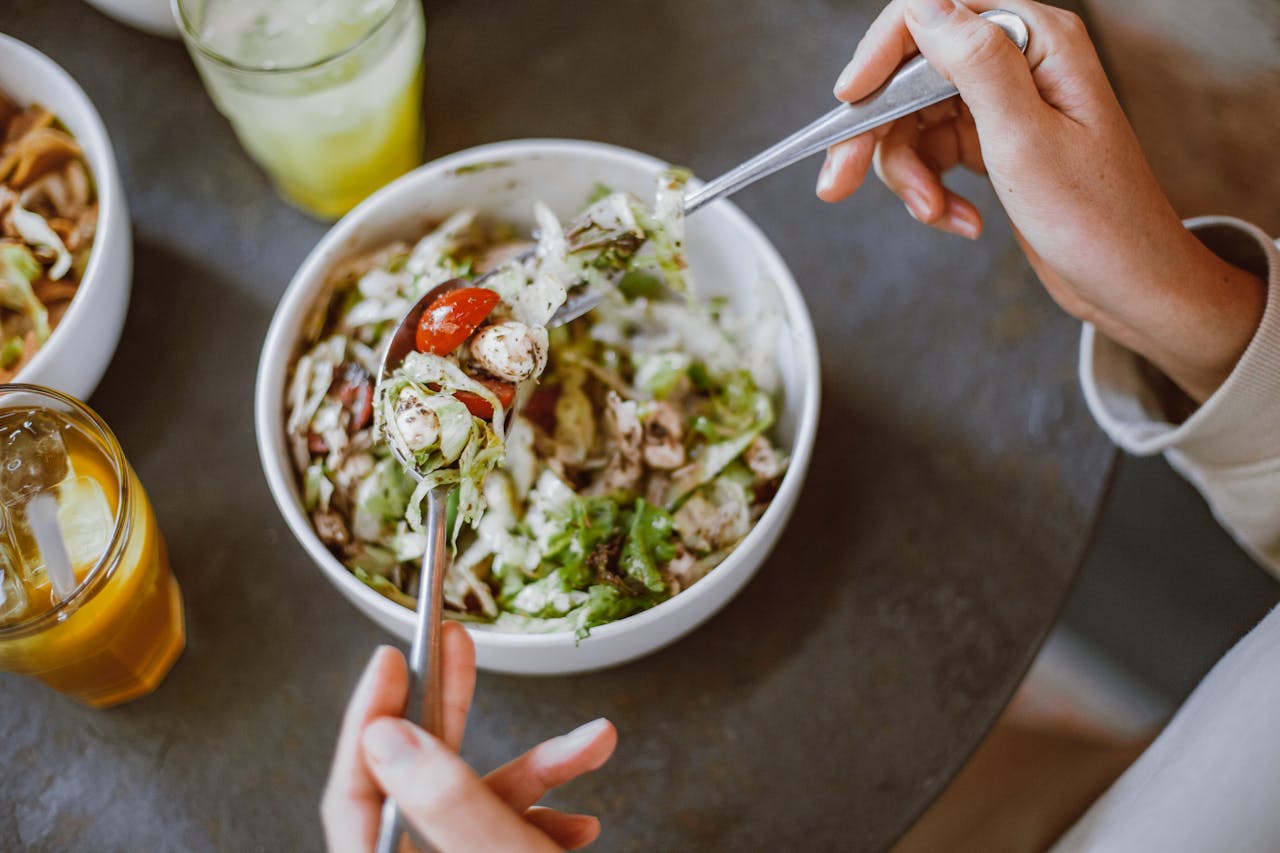 person eats salad from bowl