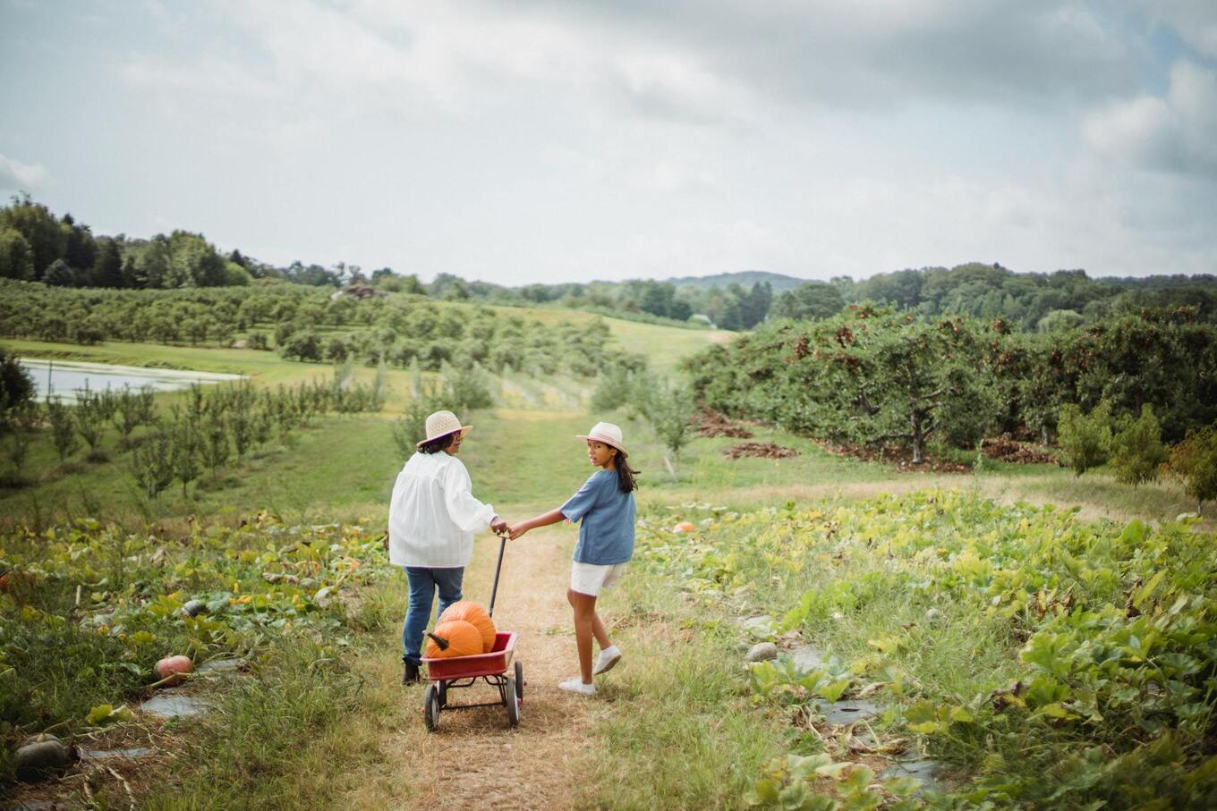 women and girl pulling pumpkin wagon