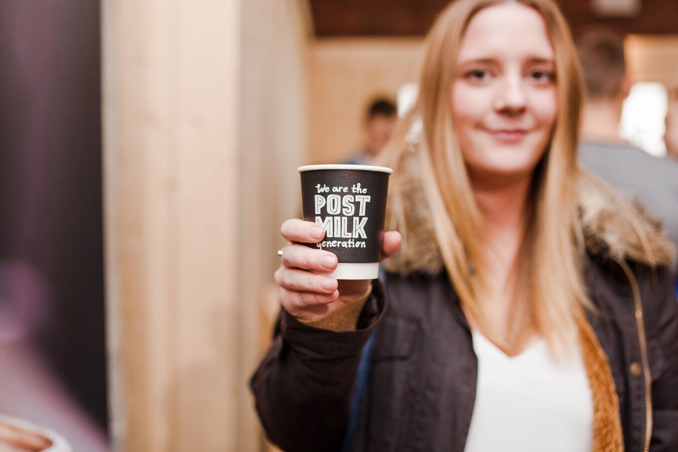 woman holds oatly cup
