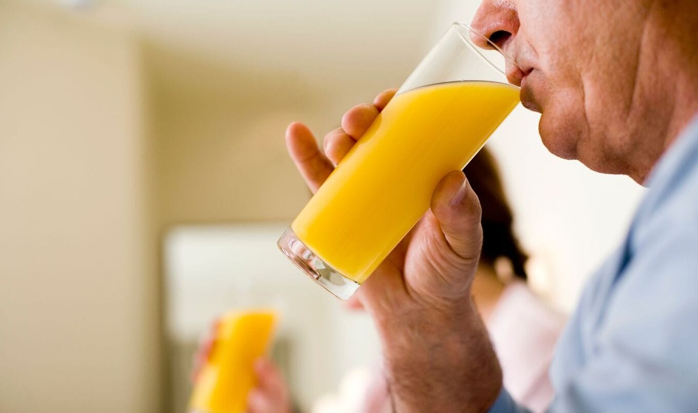 man drinking orange juice