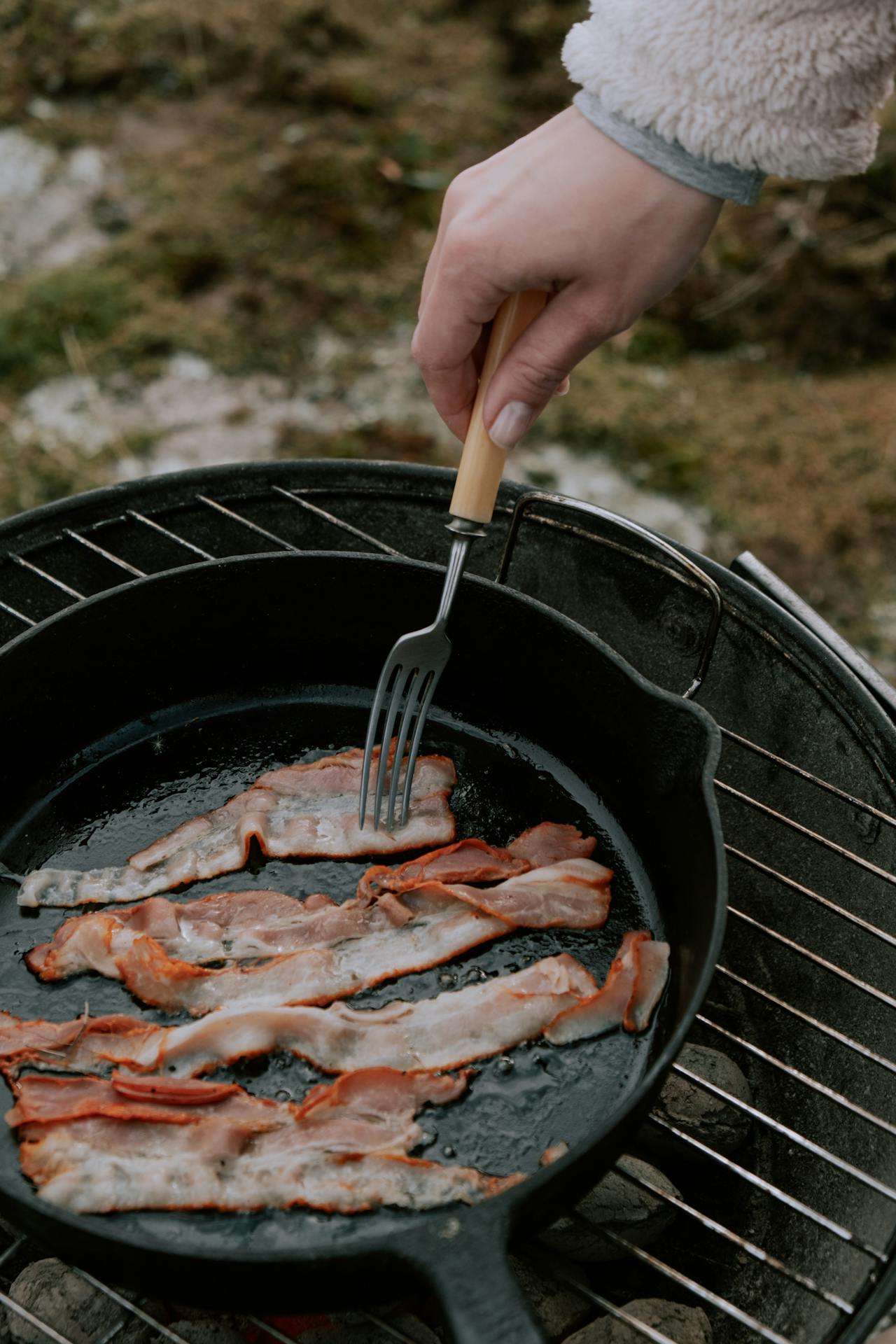 cooking bacon in pan outside