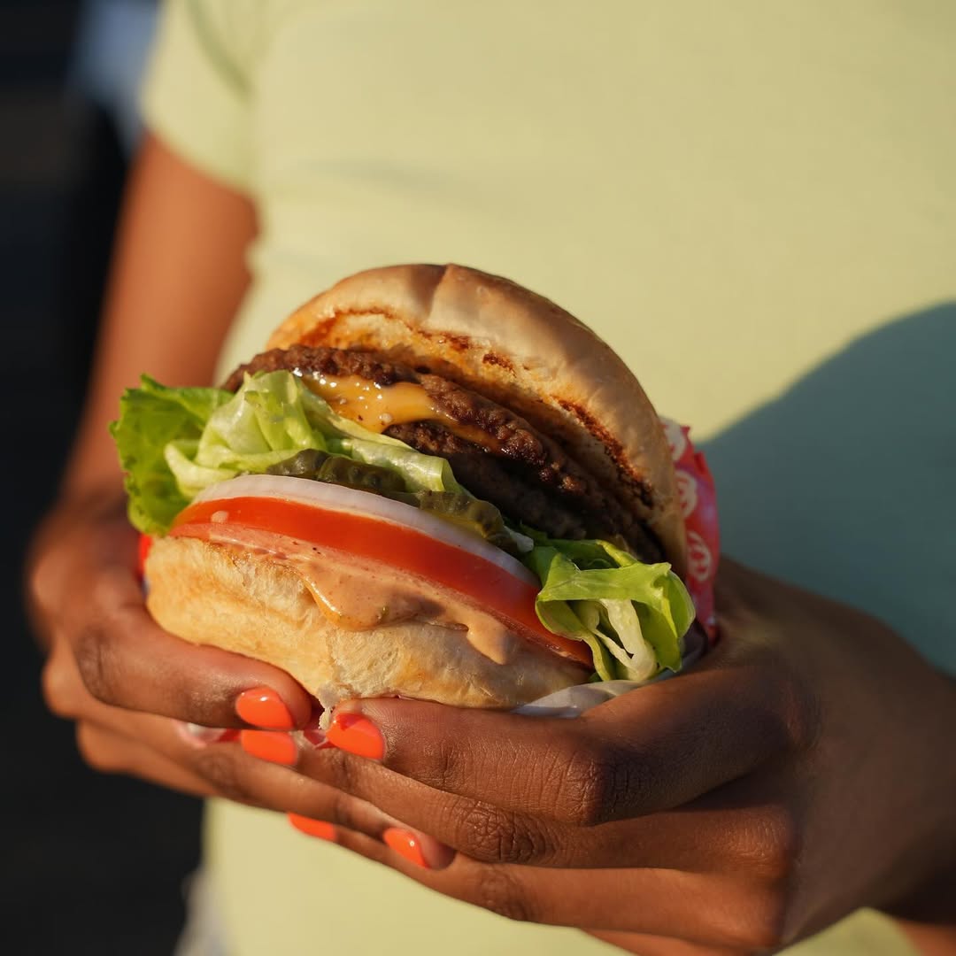 person holds Face Plant burger