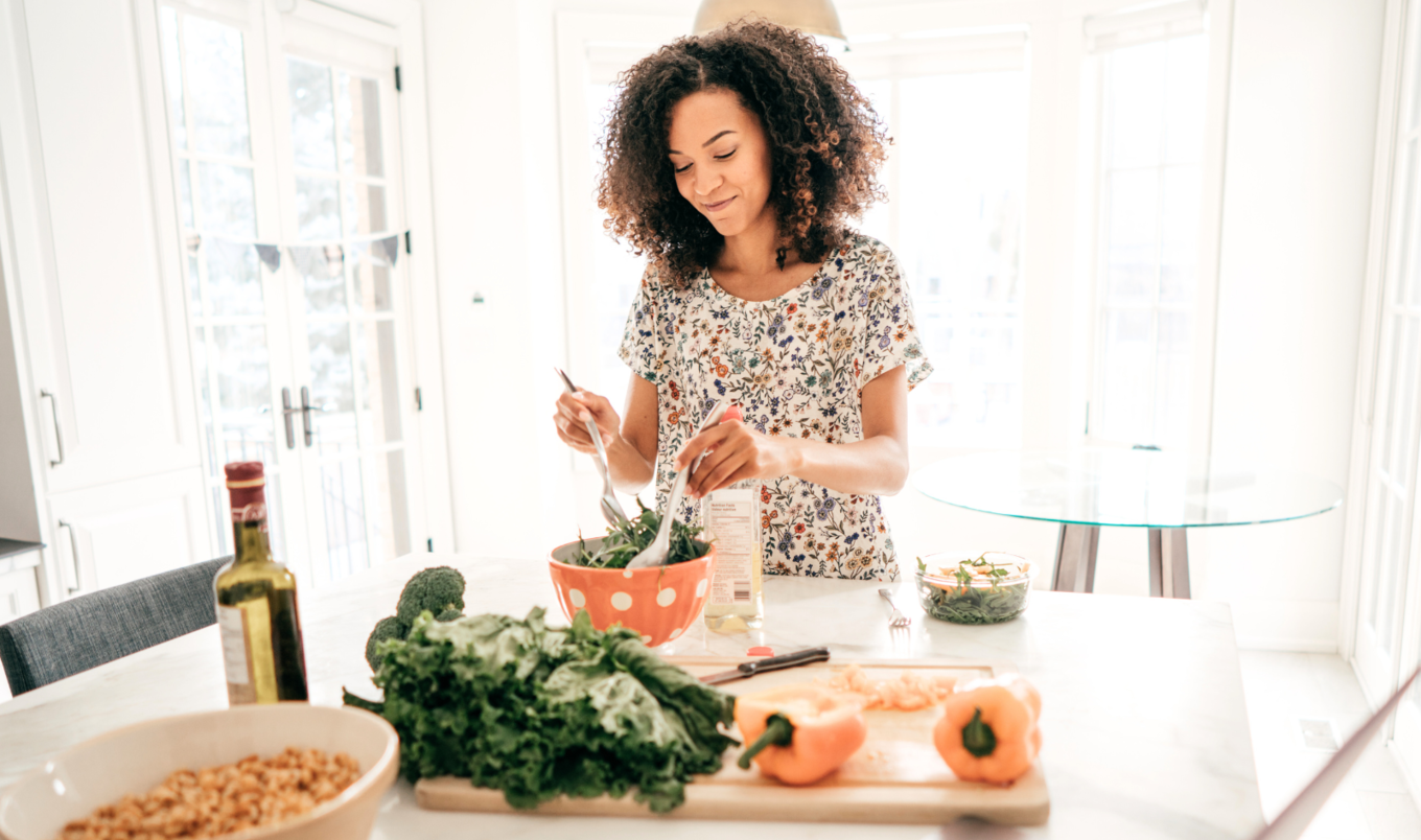 woman picks up salad with tongs