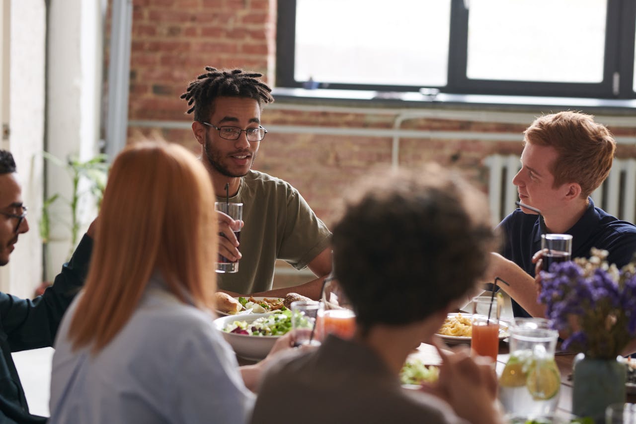 people sat around table eating dinner