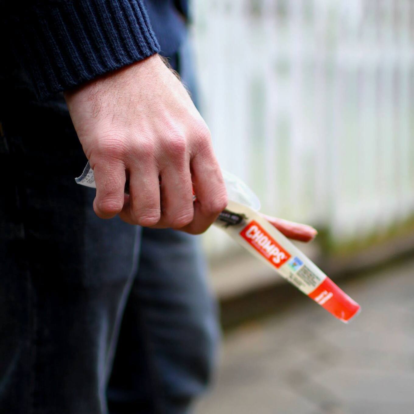 man holding Chomps meat stick