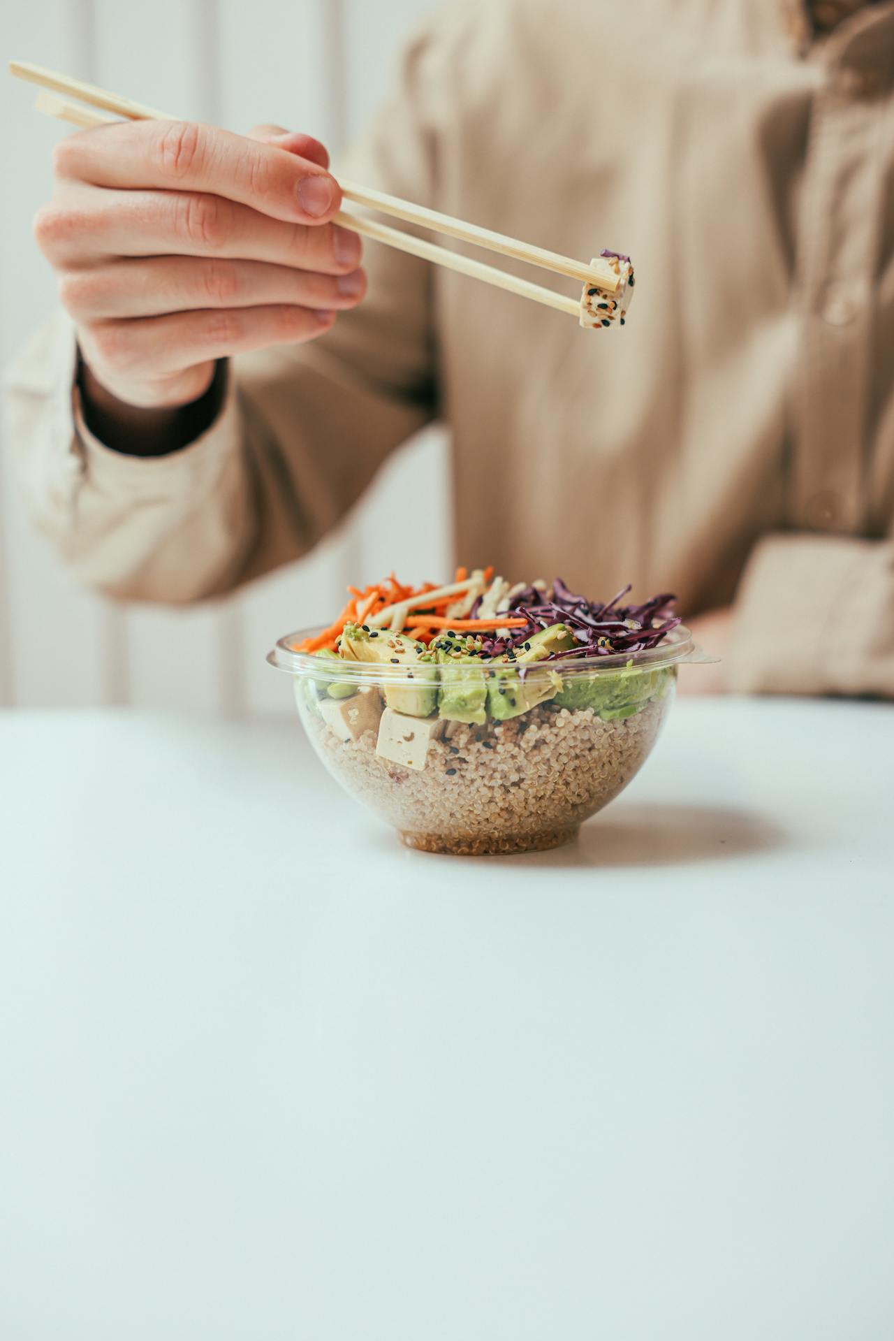 person eating tofu with chopsticks