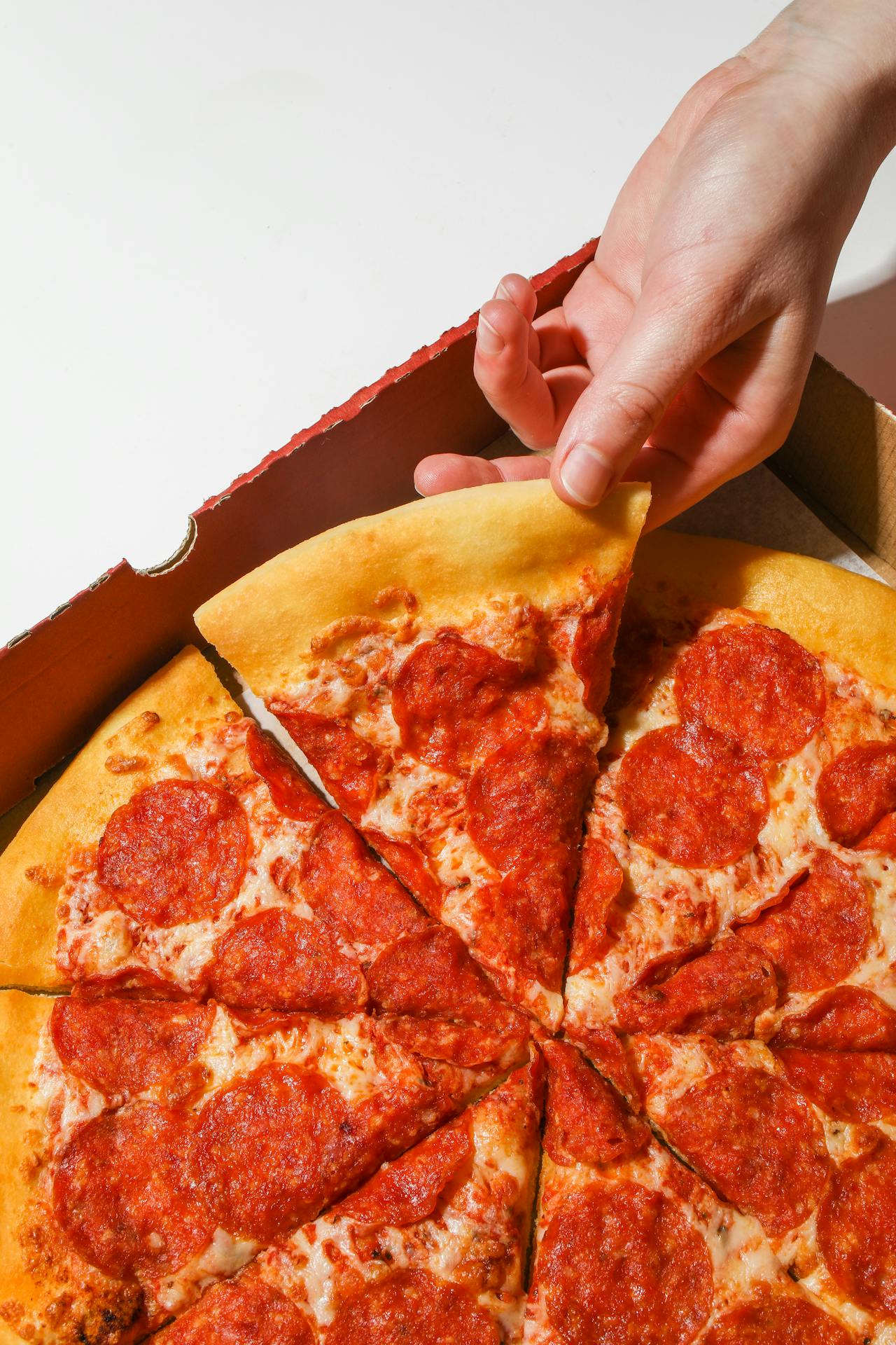 person taking pizza slice