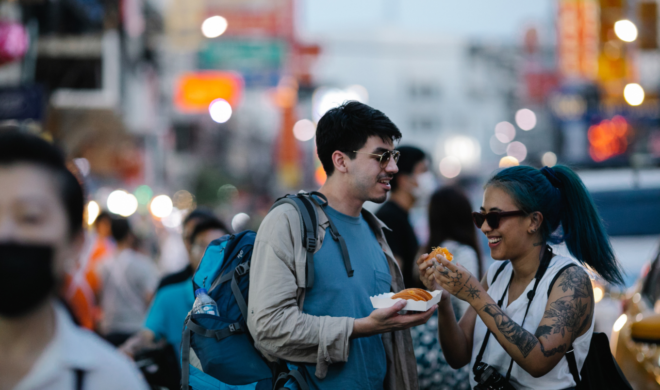 man and woman eating street food